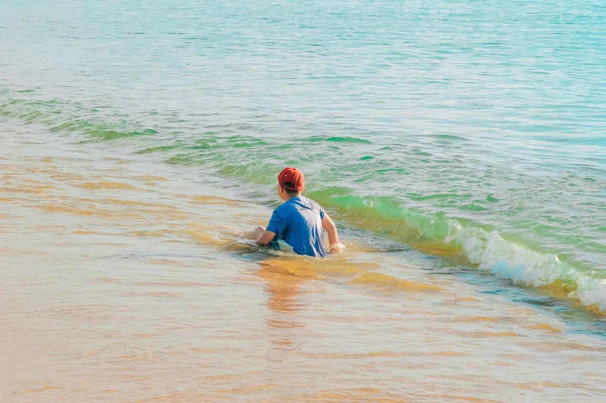 Enfant a la plage protege du soleil
